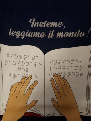 "Insieme leggiamo il mondo" - mani su un libro braille